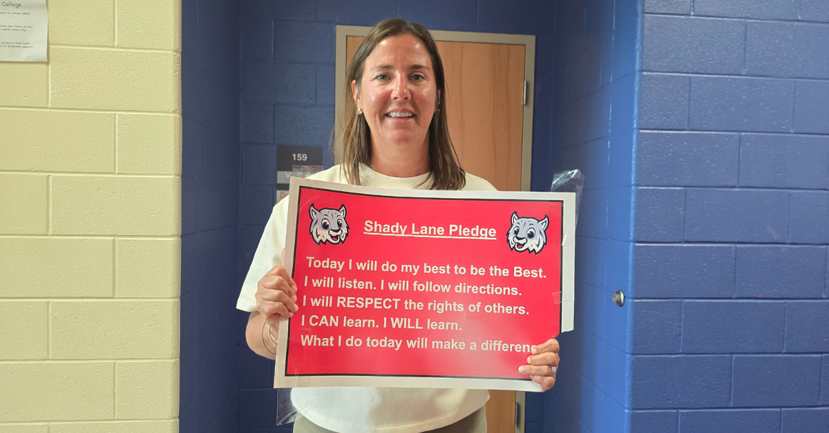 teacher holding red sign